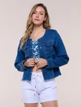Campera de denim azul oscuro con cuello mao, cierre frontal de botones metálicos, bolsillos plaqué con solapa en el pecho y detalle desflecado en el ruedo.