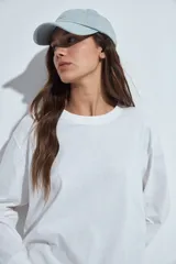 Remera de manga larga en color blanco, con corte relajado y cuello redondo. Presenta un pequeño estampado gráfico en la parte inferior frontal con la frase 'WHO WH WHO?' y un dibujo de un perro.