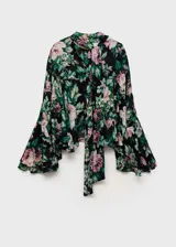 Blusa de gasa con estampado floral en tonos rosa, verde y negro. Tiene cuello alto, mangas largas con volantes y cierre de lazo en la parte posterior.