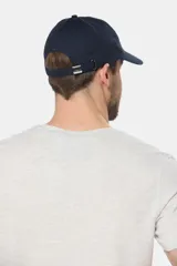 Gorro con visera de lona azul marino, con parche rectangular bordado en el frente.