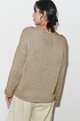 Jersey de punto de manga larga y cuello barco, con diseño holgado y acabado texturizado.
