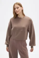 Buzo negro de corte cropped, con cuello redondo y mangas largas abullonadas.