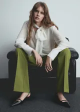 Pantalon de vestir de tiro bajo con diseño acampanado, confeccionado en tejido con acabado liso. Cuenta con trabillas en la cintura, cierre oculto de botón, gancho y cremallera, y bolsillos de ribete en la parte posterior.