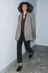 Jeans de tiro medio con corte slim leg, confeccionados en denim color beige. Presentan cintura con trabillas, diseño clásico de cinco bolsillos y cierre frontal con cremallera y botón metálico.