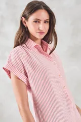 Blusa de viscosa con estampado de rayas verticales en color blanco y rosado, cuello camisero, cierre frontal con botones y mangas cortas con dobladillo.