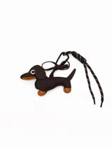 Llavero con forma de perro salchicha en cuero sintético marrón con detalles en color tostado, incluye un mosquetón metálico y una cuerda trenzada decorativa.