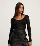 Body de encaje floral negro con escote redondo y mangas largas.