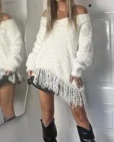 Sweater tipo poncho de punto peludo color blanco, con escote en V y flecos asimétricos en el dobladillo.