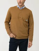 Buzo color ocre de algodón orgánico, con cuello redondo y abertura parcial con broches. Tiene un bolsillo tipo parche en el pecho con etiqueta RKF con paisaje bordado.