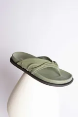 Sandalias de cuero color verde oliva, con tira ancha superior con detalle de frunce y suela plana.