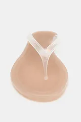 Sandalia plana tipo ojota con suela baja de color nude y tira delantera transparente de vinilo con división para el dedo.