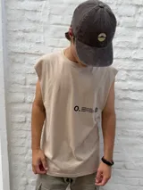 Gorro estilo jockey de color gris oscuro con efecto desgastado y un logo circular bordado en color beige claro en el frente.