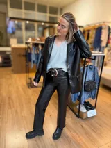 Blazer negro de eco cuero, con solapas clásicas, cierre frontal de un botón y bolsillos con solapa.