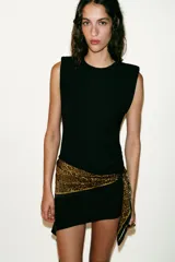 Pañuelo tipo pareo con estampado animal print, confeccionado en viscosa. Presenta un diseño triangular con cierre mediante arandelas metálicas y mosquetón.