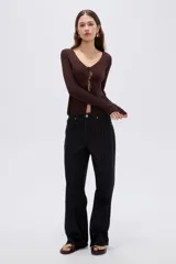 Top de manga larga en tejido de punto con lurex, color negro, de corte ajustado al cuerpo, con escote en V pronunciado y cierre delantero mediante finos lazos para anudar.