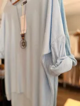 Sweater de punto con diseño oversize y corte relajado, confeccionado en una mezcla de viscosa y lana. Presenta cuello redondo, mangas largas y un largo asimétrico con la parte trasera más extensa.