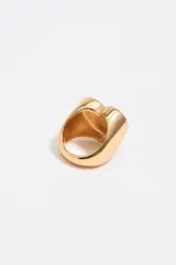 Anillo dorado con forma de corazón rojo y letras doradas.