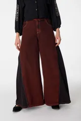 Pantalón de jean con diseño de paneles en dos tonos de azul, corte wide leg y tiro alto. Presenta un estilo patchwork con costuras visibles y terminación acampanada.