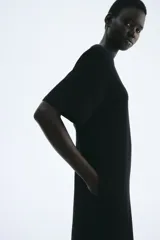 Vestido largo (tobillero) negro de corte recto y holgado, tipo remerón, con cuello redondo y mangas cortas.