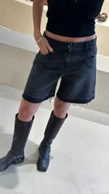 Bermuda de jean negro con ruedo desflecado y bordado con logo en el bolsillo trasero.
