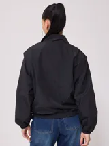 Campera rompevientos Rusty de nylon, color rosa y azul marino, con cierre frontal y puños elastizados.