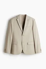 Blazer slim fit de botonadura sencilla en color beige, con solapas de muesca, bolsillos con solapa y cierre de botones.
