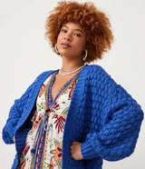 Cardigan abierto de punto con textura en relieve, mangas largas abullonadas y puños acanalados. Diseño holgado y versátil.
