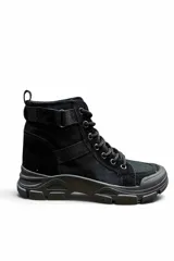 Botas borcegos negros de estilo utilitario, con suela track robusta, cordones frontales, ojetes metálicos y tiras ajustables con hebilla en la caña.