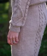 Falda midi de tiro alto tejida en lana merino color beige, con diseño de trenzas y rombos texturados en relieve.