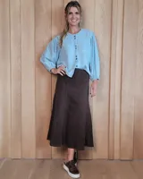 Pollera midi de denim color marrón, con diseño de paneles verticales y costuras a contratono. Presenta un corte amplio y cierre posterior.