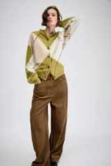 Pantalón de tiro medio confeccionado en tejido de pana, con diseño de pierna ancha, bolsillos delanteros y traseros, y cierre frontal con cremallera y botón.
