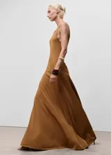 Vestido largo de punto fino, color tostado, con cuello redondo, sin mangas y diseño evasé.