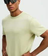 Remera deportiva de manga corta y cuello redondo, confeccionada con tecnología Dry para mayor transpirabilidad y control de la humedad. Presenta un diseño liso en color verde claro con un pequeño estampado de lettering en la parte inferior.