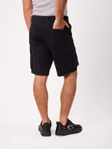 Bermuda cargo de gabardina color beige, con bolsillos laterales con fuelle en las piernas, bolsillos delanteros tipo ojal y traseros. Cuenta con presillas para cinto y cierre frontal con botón y cierre.