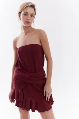 Vestido corto strapless de color negro con destellos en lúrex, de diseño recto y falda con volados.