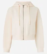 Saco color crema, de corte slim, confeccionado en algodón con viscosa certificada, con cuello con capucha y cordón ajustable, cierre frontal con cremallera y forro de fleece.