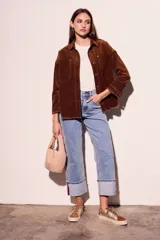 Sobrecamisa de pana color rojo, con cierre frontal de botones, bolsillos delanteros con solapa y ruedo desflecado.