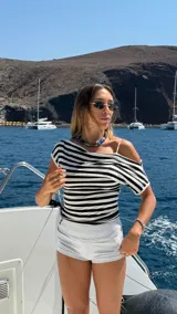 Remera de manga corta con rayas horizontales blancas y negras, con escote amplio que permite llevarla con un hombro caído.