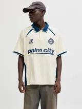Camiseta tipo polo de manga corta con calce holgado, confeccionada en tejido liviano y flexible. Presenta cuello clásico, detalles en contraste y estampados gráficos en el frente con estilo deportivo.