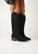 Botas texanas de cuero color beige con caña alta, taco de madera y cierre lateral.