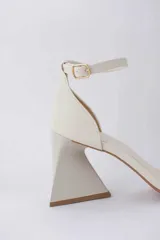 Sandalias color crema con tira delgada sobre los dedos, pulsera al tobillo con hebilla y taco geométrico.