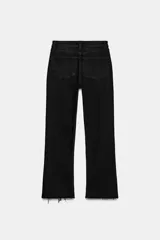 Jeans de tiro alto con diseño cropped flare, confeccionados en denim azul con acabado desgastado. Presentan cinco bolsillos, cierre frontal con cremallera y botón metálico, y bajo con terminación sin costuras.