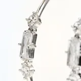 Aros plateados tipo argolla con tres cristales engarzados: dos circulares y uno rectangular.