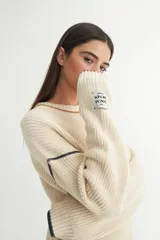 Sweater tejido de punto color ladrillo, con cuello redondo y calce oversize.