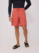 Short de baño color terracota/coral con cordón ajustable en la cintura y un ribete negro vertical en el lateral.