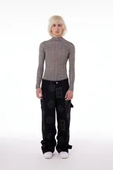 Polera de cuello alto y manga larga, confeccionada en tela elastizada con estampado de figuras geométricas en tonos beige y negro.