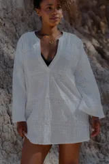 Camisa blanca de broderie con escote en V y mangas largas.