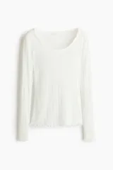 Remera de manga larga de punto pointelle acanalado, color blanco, con escote en U y detalles de ondas en los puños y el bajo.