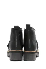 Borcego de cuero color beige con cordones, suela track de goma y detalle de hebilla metálica en el empeine.