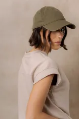 Sweater de punto color blanco, de corte relajado, con cuello redondo, manga corta japonesa de hombro caído y pretina ancha en la cintura.